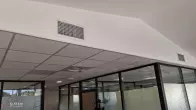 Grilles de soufflage intégrées au-dessus des cloisons vitrées des bureaux